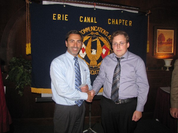 In June, Jack LoSecco (l), assistant vice president for intelligence and information systems, Syracuse Research Corporation, presents a $3,000 scholarship award to James Bohl, a student at the State University of New York Institute of Technology, in recognition of his outstanding academic achievements.